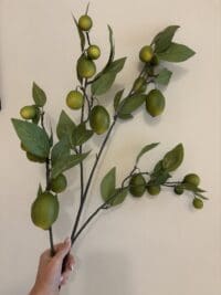 Realistische citroen kunsttak met levensechte gele citroenen en groene bladeren in decoratieve vaas