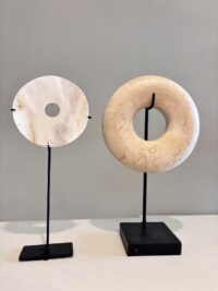 Rond natuurlijk ornament van marmer en ornament van bot als stijlvolle woondecoratie op een dressoir.