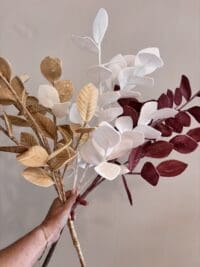 Kunsttak met kleine blaadjes in wit, oud roze of beige voor stijlvolle woondecoratie in een vaas.
